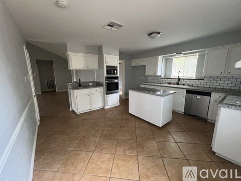 A kitchen with white cabinets and appliances is available for rent.