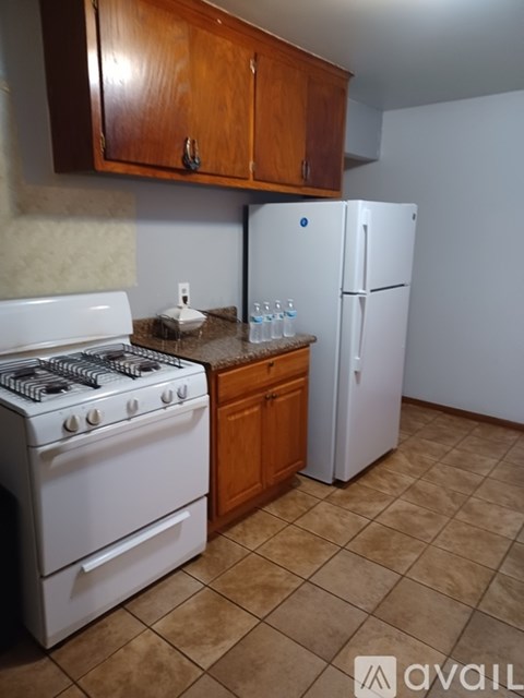 A kitchen with a white stove and a white refrigerator.