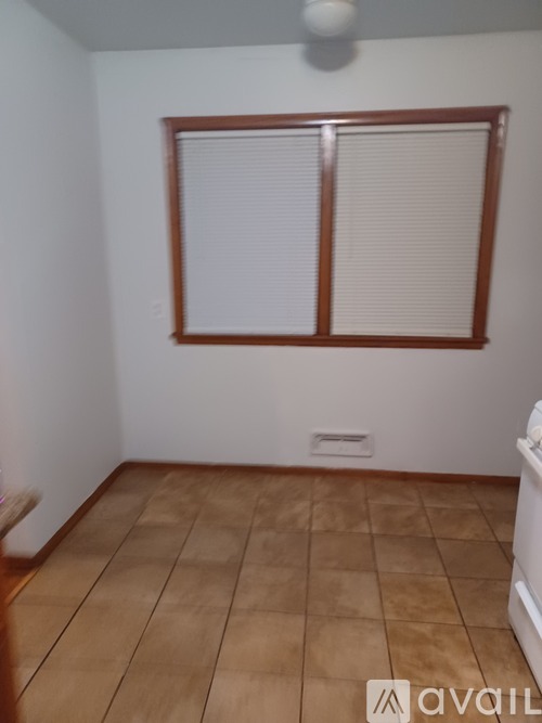 A room with a window and tiled floor.