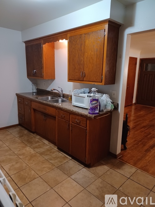 A kitchen with brown cabinets and a tiled floor.
