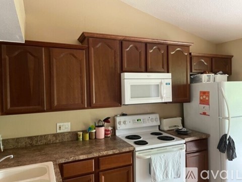 A kitchen with brown cabinets and a white stove top oven.