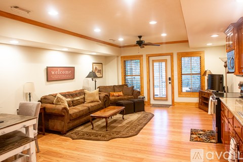 A living room with a brown couch and a wooden floor.