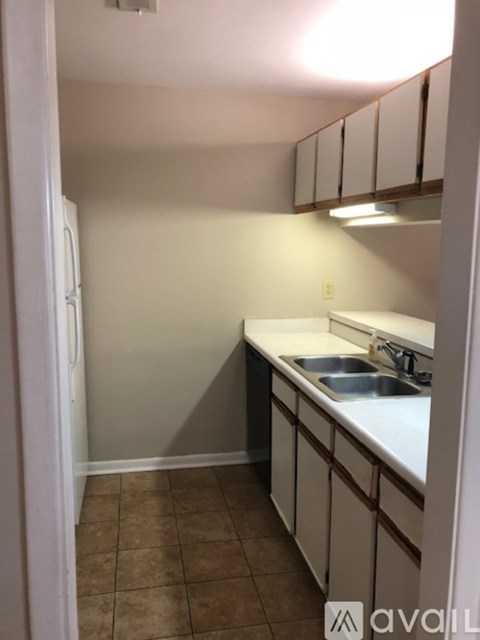 A kitchen with a sink and a refrigerator.