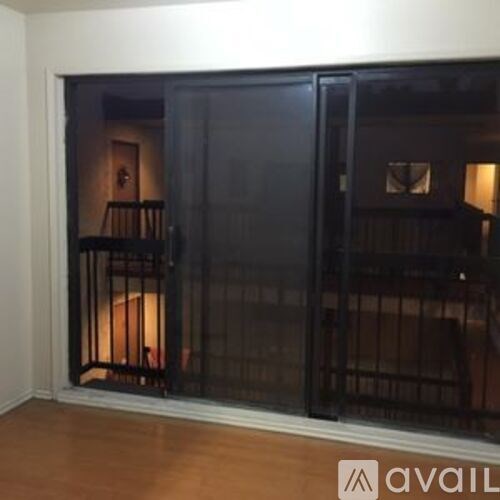 A room with a black door and a lamp inside.