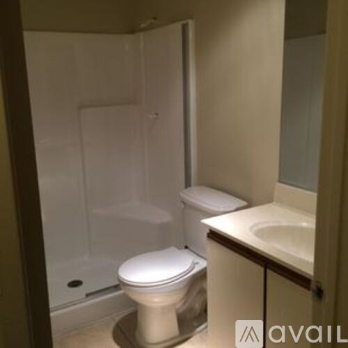 A white toilet sits in a bathroom next to a sink.