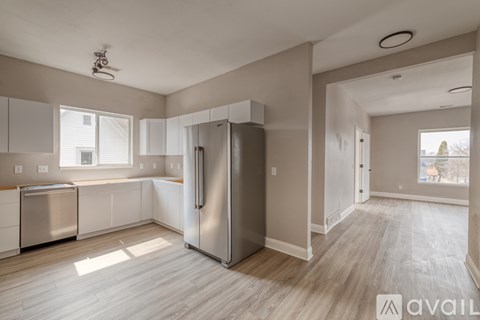 A kitchen with a refrigerator, dishwasher, and stove top oven.