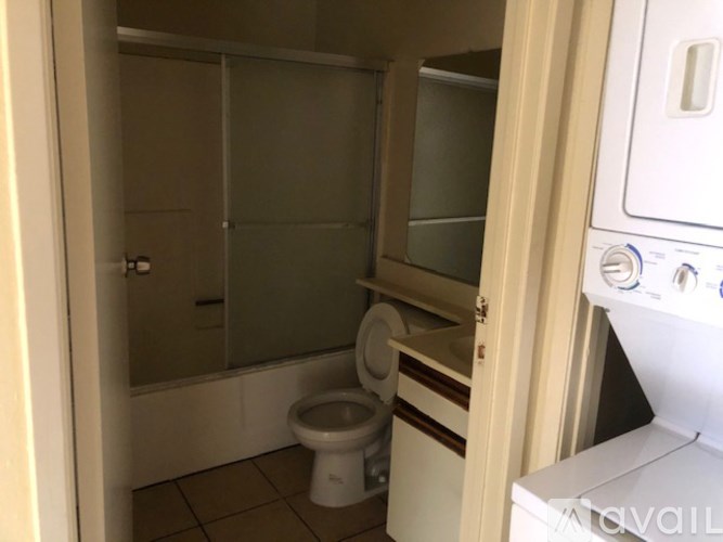 A small bathroom with a toilet and a washing machine.