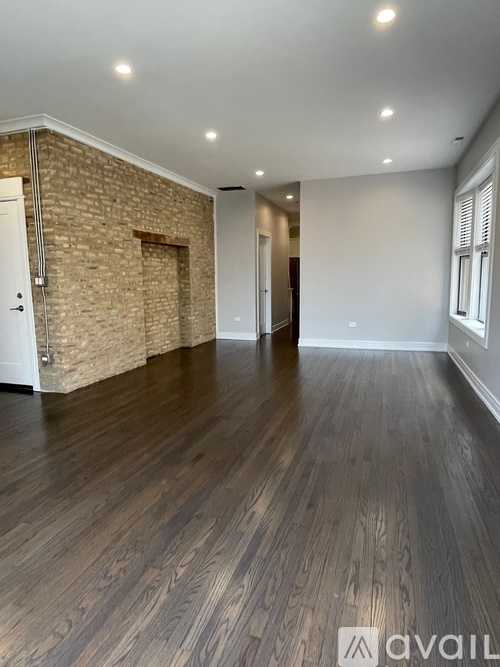 A room with wooden flooring and a brick wall.