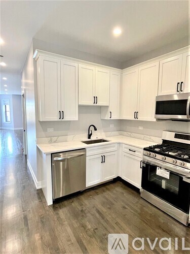 A kitchen with white cabinets and a stainless steel dishwasher.