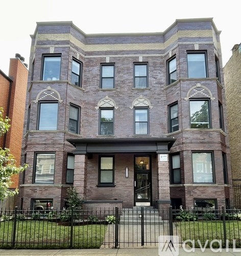 A large brick building with a black gate in front.