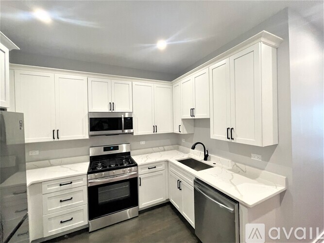 A kitchen with white cabinets and appliances.