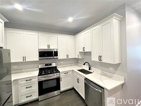 A kitchen with white cabinets and appliances.