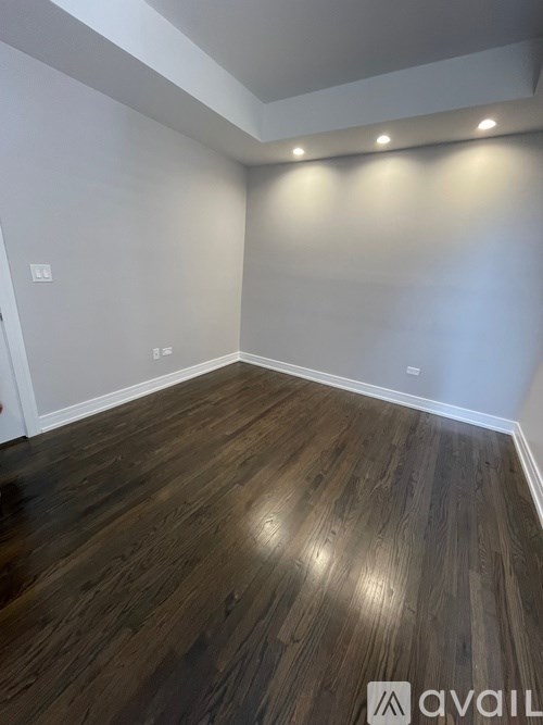 A room with wooden flooring and white walls.