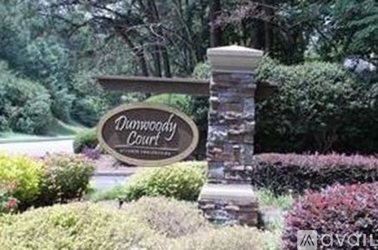 A sign that says Hamwood Court stands in front of a garden.