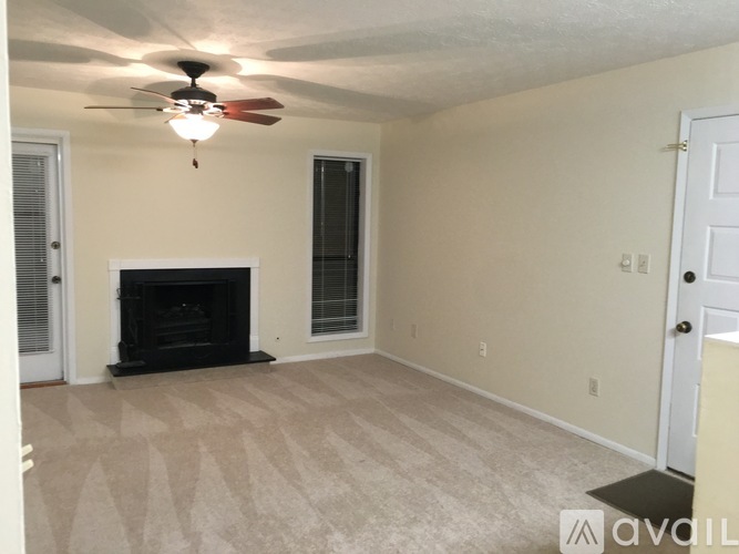 A living room with a fireplace and a ceiling fan.