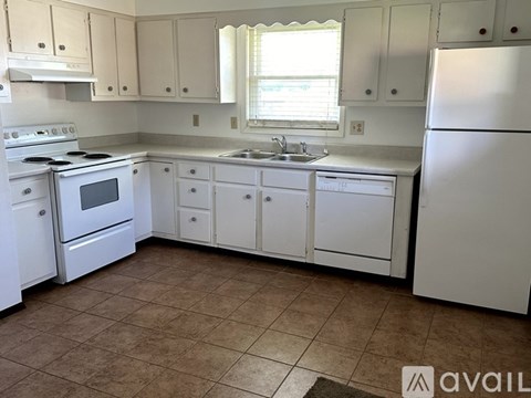 A kitchen with white appliances and cabinets.