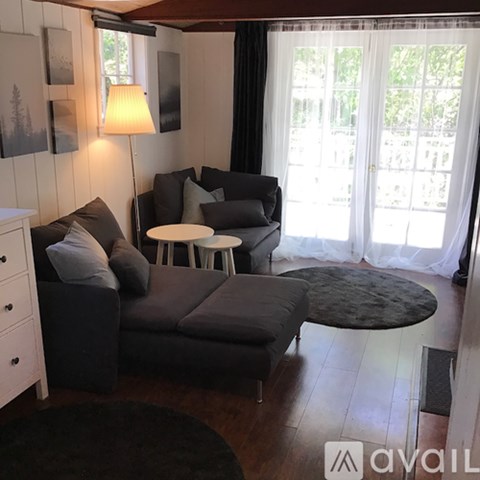 A living room with a grey couch and a white table.