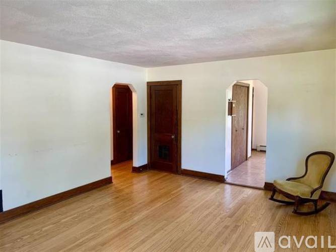 A room with a wooden floor and a chair.