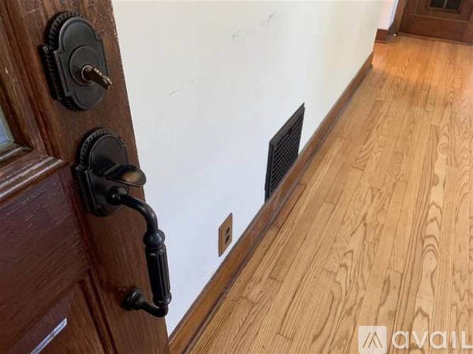 A close up of a door handle and lock on a wooden door.