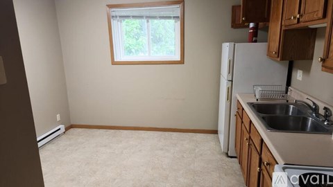 A kitchen with a white refrigerator and a window.