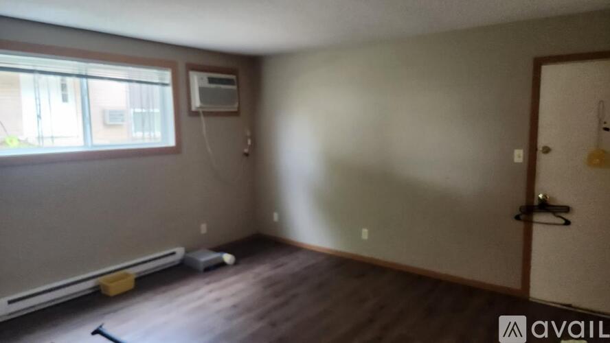 A room with a window, a door, and a wall-mounted air conditioner unit.