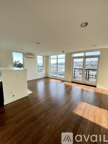 A spacious room with wooden floors and large windows overlooking a snowy landscape.