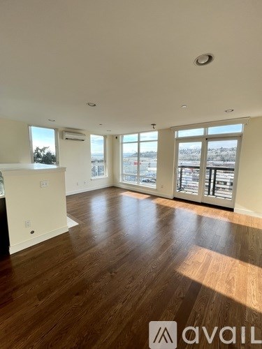 A spacious room with wooden floors and large windows overlooking a snowy landscape.