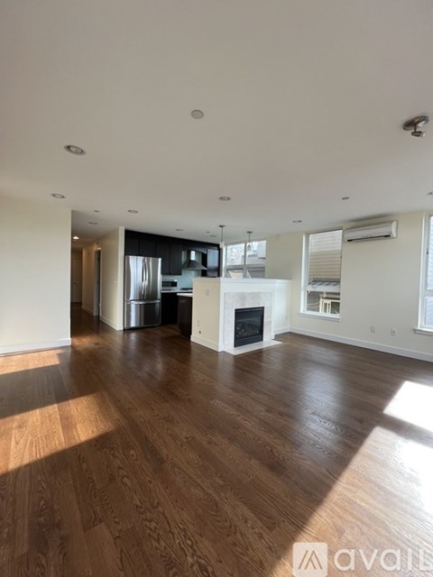 A living room with wooden floors and a fireplace.