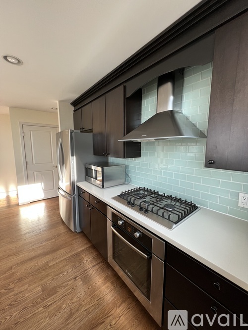 A kitchen with a stove top oven and a refrigerator.