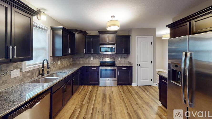 A kitchen with wooden floors and stainless steel appliances.