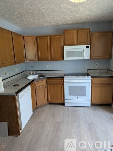 A kitchen with wooden cabinets and a white oven.