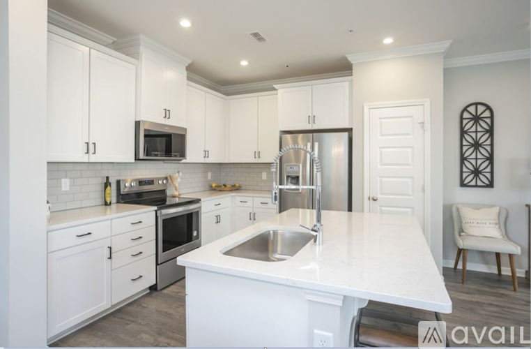 A modern kitchen with white cabinets and stainless steel appliances.