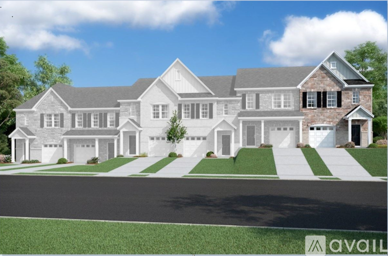 A large, modern house with a grey roof and white walls.
