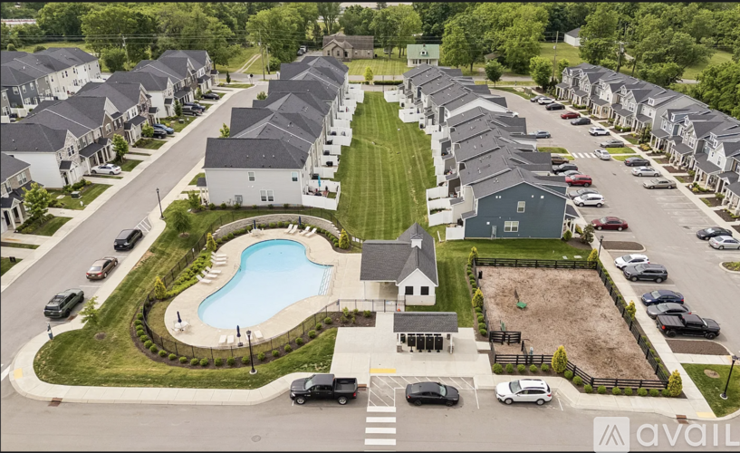 A bird's eye view of a residential area with houses, cars, and a swimming pool.