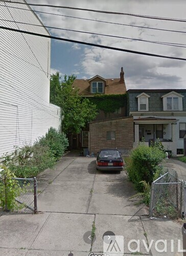 A car is parked on a driveway in front of a house.