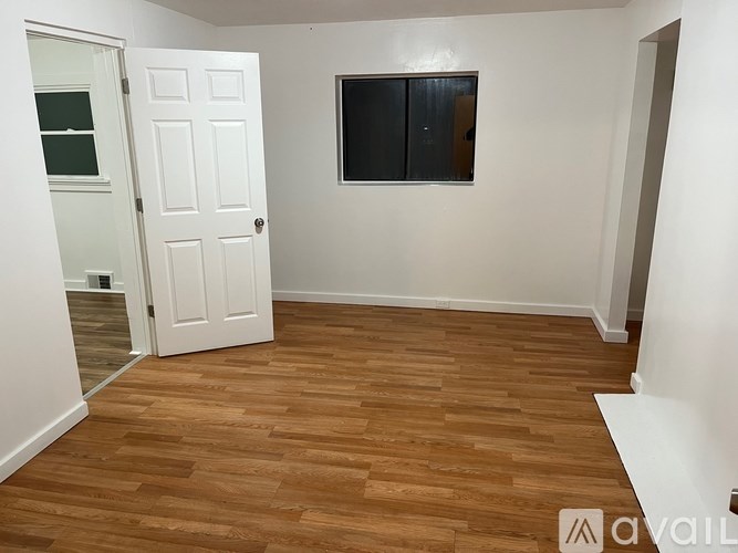 A room with a wooden floor and a white door.
