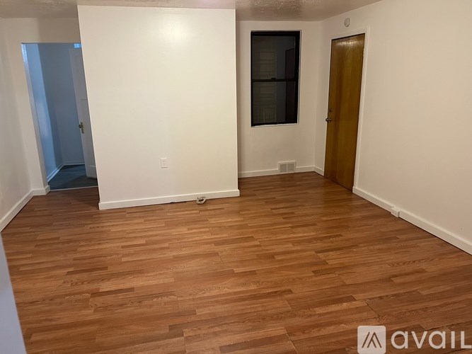 A room with wooden flooring and white walls.