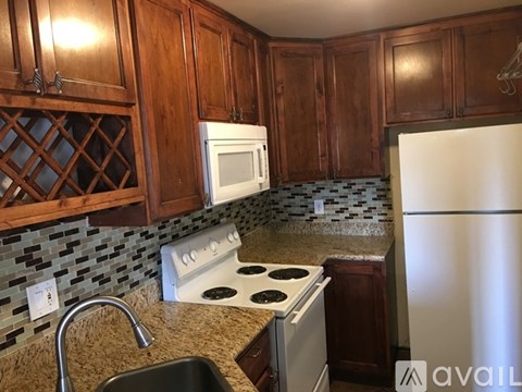 A kitchen with a white stove top oven and a white microwave above a white dishwasher.