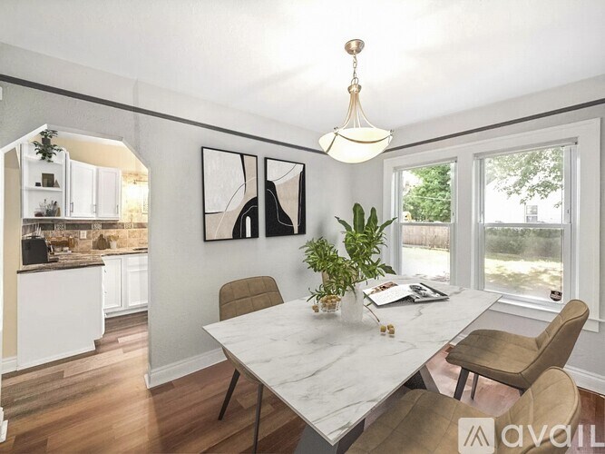 A dining room with a marble table and chairs.