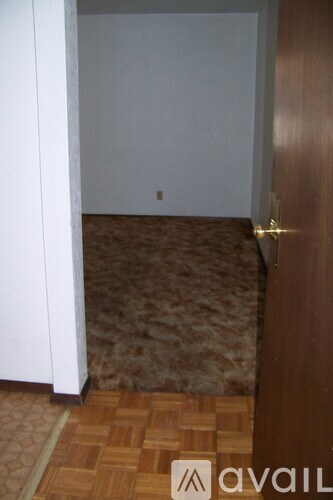 A room with a brown carpet and wooden floor.