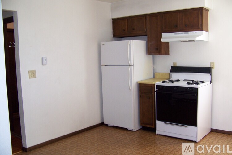 A kitchen with a white refrigerator and a black stove top oven.