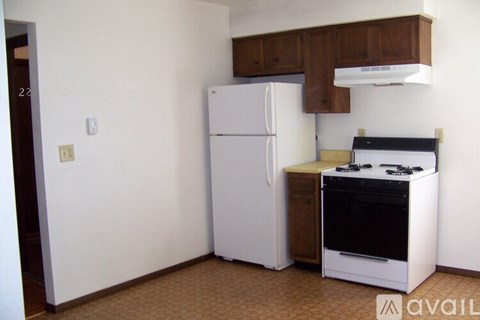 A kitchen with a white refrigerator and a black stove top oven.