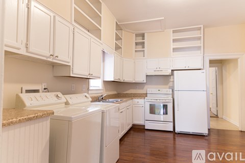 A kitchen with white appliances and cabinets.