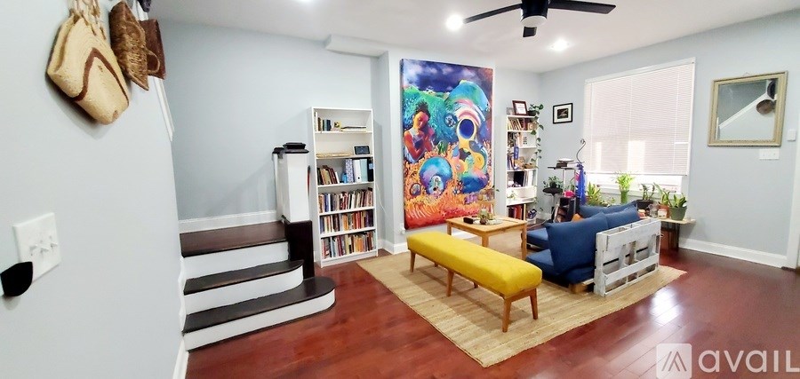 A living room with a blue couch and a yellow bench.