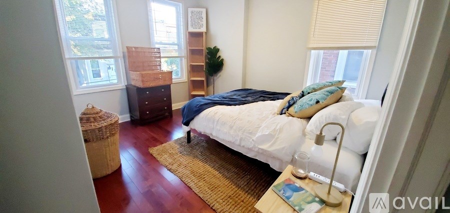 A bedroom with a bed, nightstand, and window.