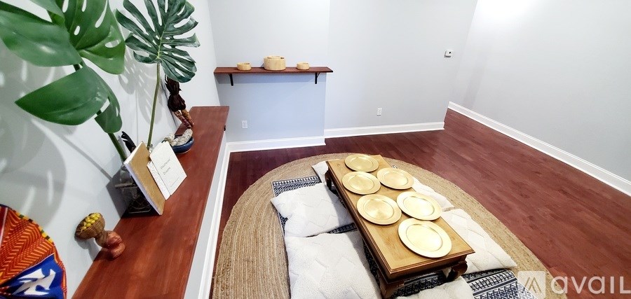 A room with a long table and a plant on the left side.