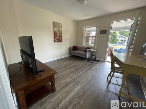 A living room with a television on a wooden stand.