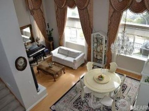 A living room with a white sofa, a coffee table, and a rug.