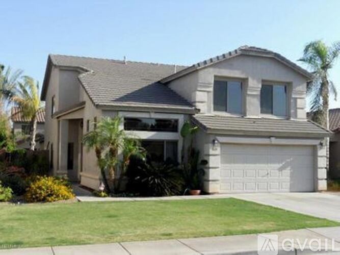 A two-story house with a garage and a driveway.