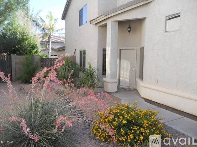 A house with a white door and a small garden in front.